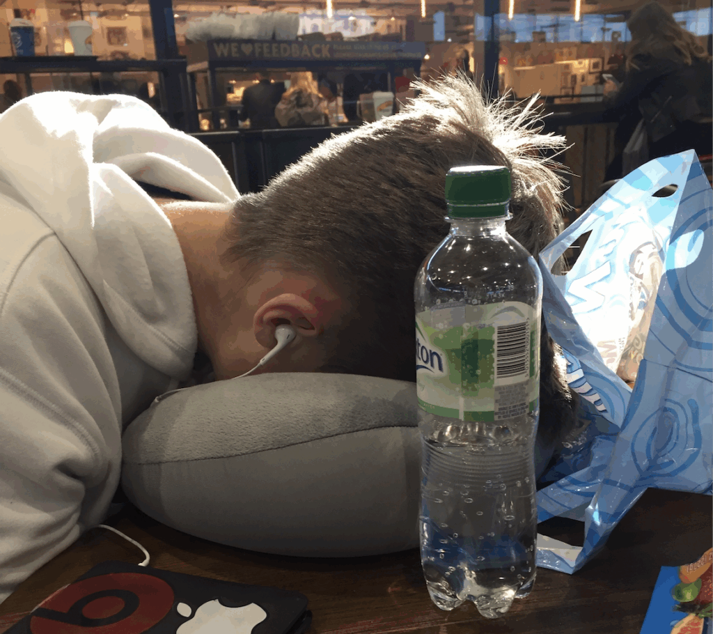 A photo of an exhausted traveler with his head in a pillow